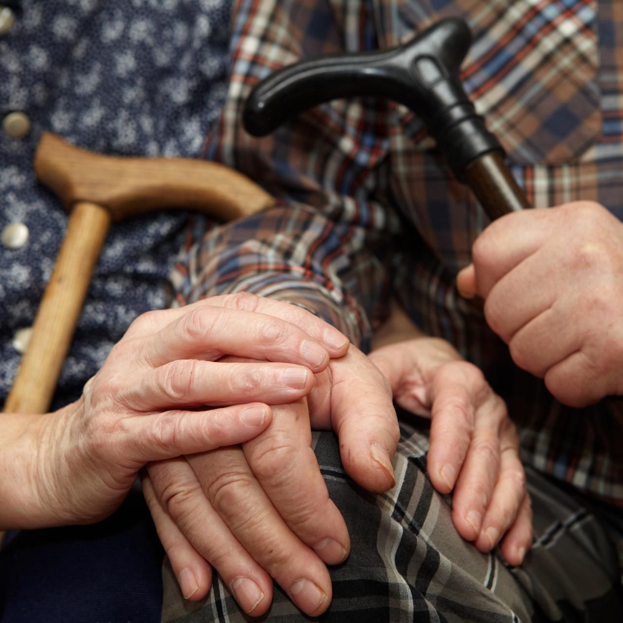 Older couple holding hands.